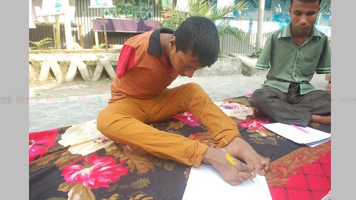 পা দিয়ে লিখছে ছাত্ররা